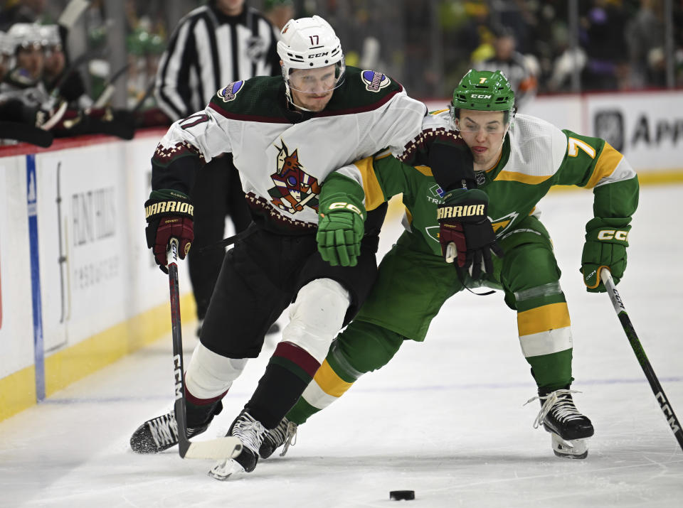 Arizona Coyotes center Nick Bjugstad, right, and Minnesota Wild defenseman Brock Faber (17) race to the puck during the second period of an NHL hockey game Saturday, Jan. 13, 2024, in St. Paul, Minn. (AP Photo/Craig Lassig)