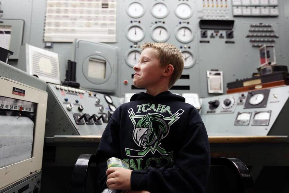 A student sits in the control room chair of B Reactor as his class attended a 2015 ceremony at the historic Hanford reactor to mark the creation of the Manhattan Project National Historic Park. Tri-City Herald file