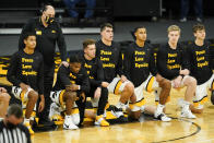 Iowa players kneel on the court before the playing of the national anthem before an NCAA college basketball game against North Carolina Central, Wednesday, Nov. 25, 2020, in Iowa City, Iowa. (AP Photo/Charlie Neibergall)