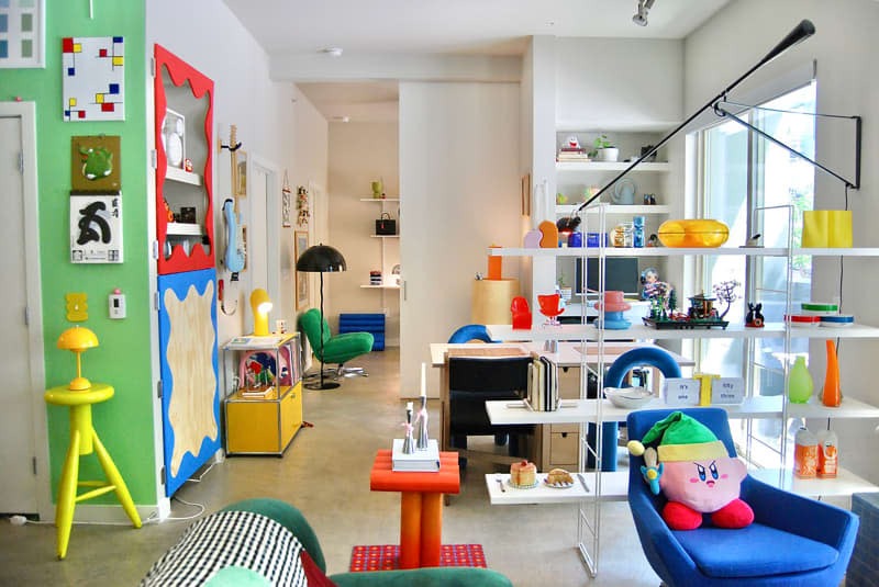 Shelving dividing living room from office space in open, airy apartment.