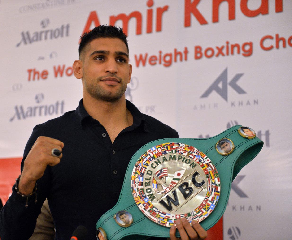 El boxeador británico de origen paquistaní Amir Khan exhibe su título de la WBC previo a una conferencia de prensa el 24 de diciembre de 2014 en Islamabad (AFP | Aameir Quereshi)