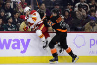 Philadelphia Flyers' Rasmus Ristolainen, right, checks Calgary Flames' Dennis Gilbert during the second period of an NHL hockey game, Monday, Nov. 21, 2022, in Philadelphia. (AP Photo/Derik Hamilton)