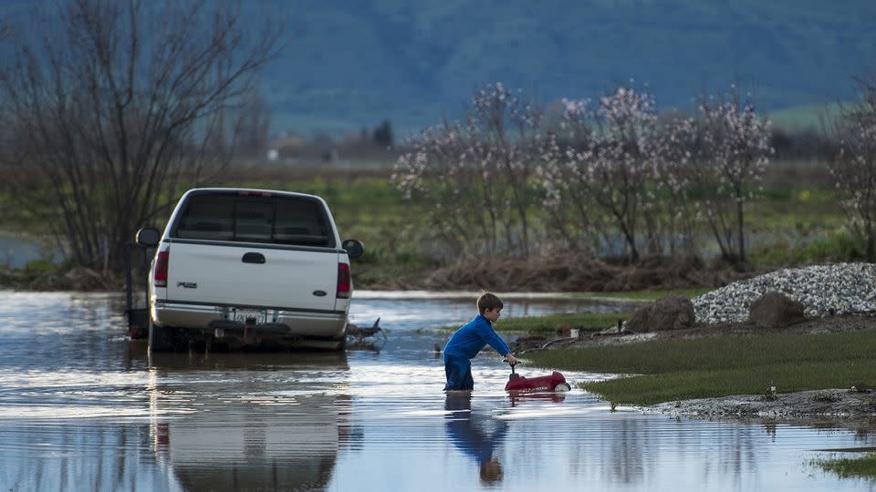 Barr Torrens, 5, plays in flooded neighborhood streets after a deluge of rain and water-runoff flooded much of Maxwell, California. Source: AP