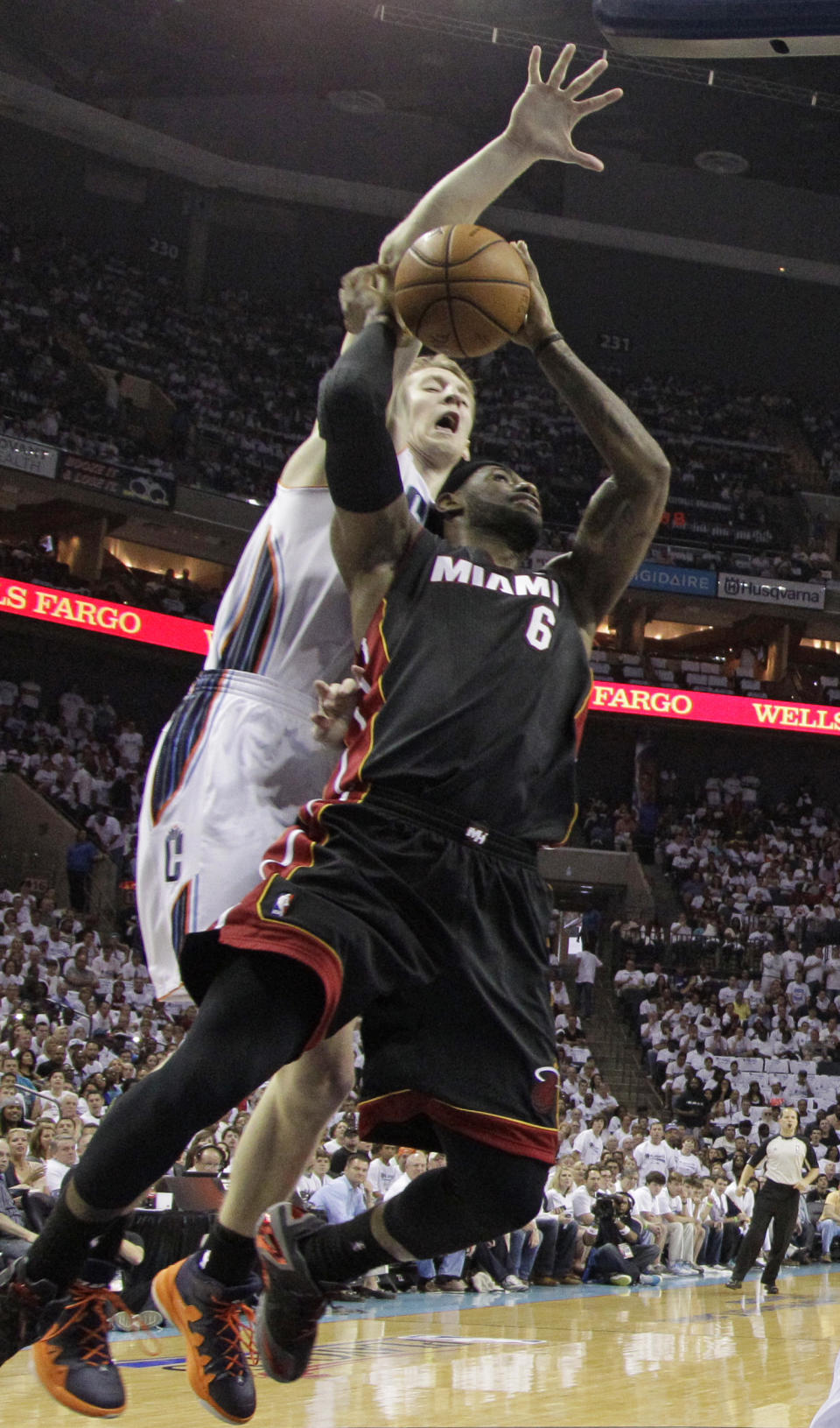 Charlotte Bobcats' Cody Zeller, back, goes up to block the shot of Miami Heat's LeBron James, front, during the first half in Game 3 of an opening-round NBA basketball playoff series in Charlotte, N.C., Saturday, April 26, 2014. (AP Photo/Chuck Burton)