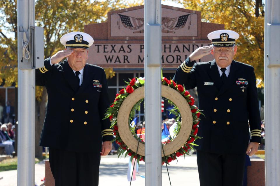 U.S. Navy submarine officers, LCDR Jim Gallagher and CDR Jim Elfelt, salute the wreath that they placed at the base of the flag poles during the 2021 Texas Panhandle War Memorial Veterans Day Ceremony, honoring those who have served in the military.
