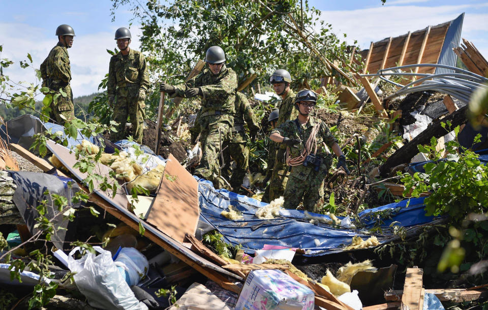 Japan Ground Self-Defense Force personnel search for missing persons at the site of a landslide triggered by a powerful earthquake in Atsuma town, Hokkaido, northern Japan, Thursday, Sept. 6, 2018. Several people were reported missing in the nearby the town, where a massive landslide engulfed homes in an avalanche of soil, rocks and timber. (Yu Nakajima/Kyodo News via AP)