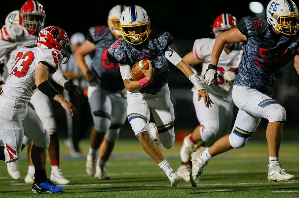 Olentangy Braves quarterback Ethan Grunkemeyer (6) runs up the middle past Thomas Worthington Cardinals linebacker Trevor Caruso (23) during the first half of the high school football game at Olentangy High School in Lewis Center on Friday, Oct. 1, 2021.