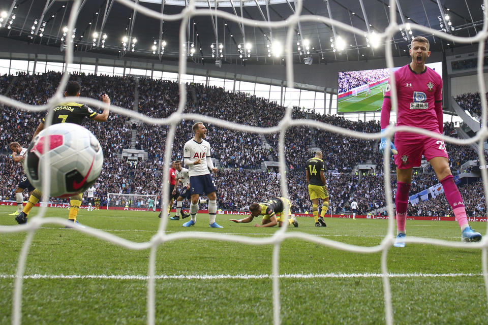 Southampton's goalkeeper Angus Gunn screams as he watches Tottenham's Harry Kane's shot, far left celebrating, go into the net as he scored his side's second goal during the English Premier League soccer match between Tottenham Hotspur and Southampton at the White Heart Lane stadium in London, Saturday, Sept. 28, 2019. Tottenham's Christian Eriksen, center, celebrates. (AP Photo/Ian Walton)