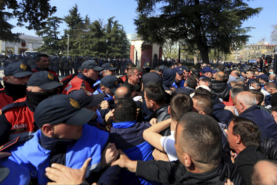 Protesters and police officers push each other during an anti-government rally in Tirana, Albania, Thursday, March 21, 2019. Thousand opposition protesters have gathered in front of Albania's parliament building calling for the government's resignation and an early election. Rally is part of the center-right Democratic Party-led opposition's protests over the last month accusing the leftist Socialist Party government of Prime Minister Edi Rama of being corrupt and linked to organized crime. (AP Photo/ Hektor Pustina)