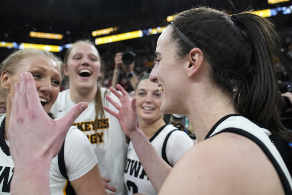 Iowa guard Caitlin Clark, right, celebrates with teammates after the overtime win against Nebraska of NCAA college basketball game in the final of the Big Ten women's tournament Sunday, March 10, 2024, in Minneapolis. (AP Photo/Abbie Parr)