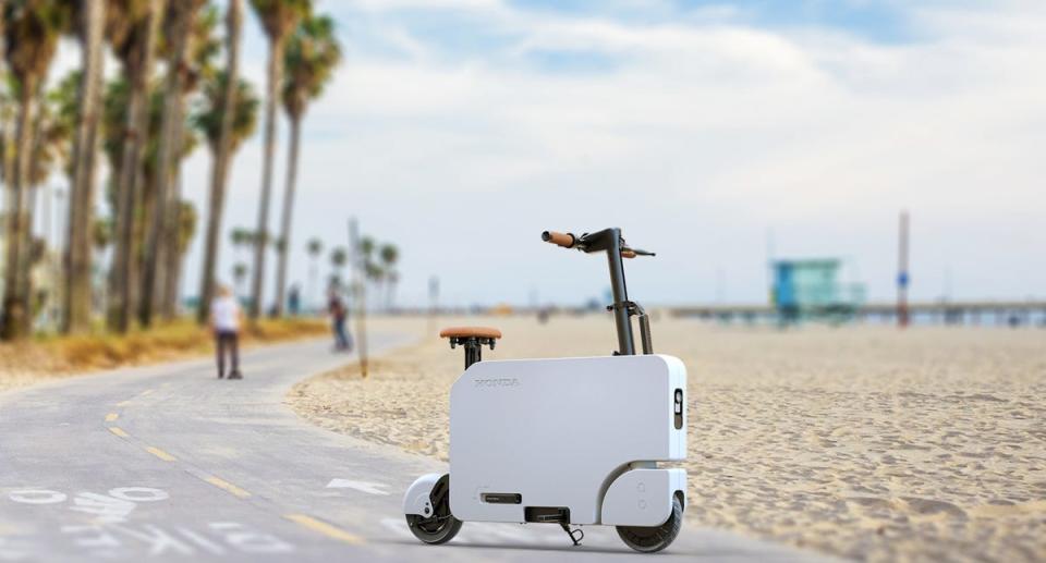 The Honda Motocompacto electric scooter on a beach. 