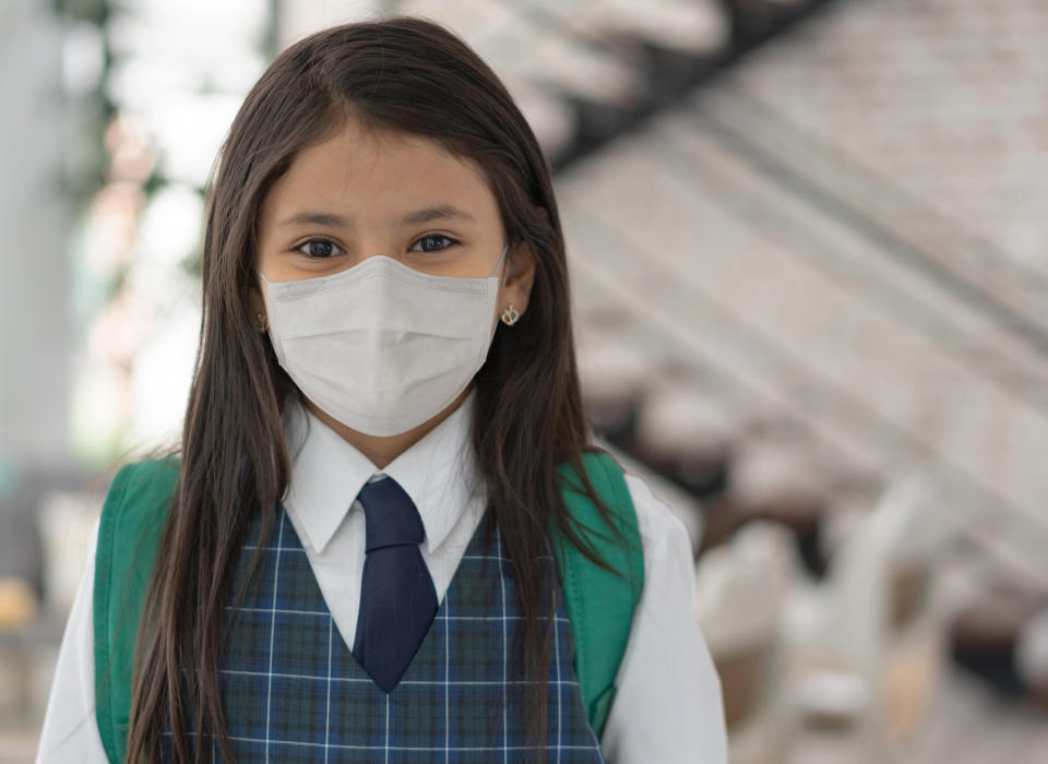 Portrait of a girl going to school wearing a facemask to avoid the spread of coronavirus - lifestyle during the COVID-19 pandemic concepts   (Portrait of a girl going to school wearing a facemask to avoid the spread of coronavirus - lifestyle duri