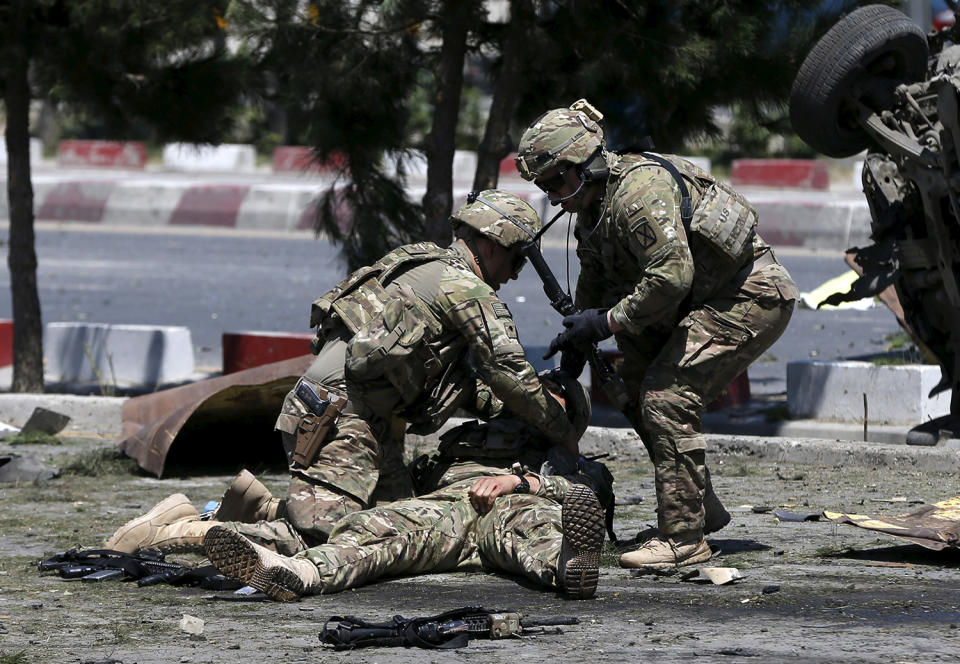 <p>U.S. soldiers attend to a wounded soldier at the site of a blast in Kabul, Afghanistan June 30, 2015. At least 17 people were wounded in a suicide bomb attack on NATO troops as their truck convoy passed down the main road running between Kabul’s airport and the U.S. embassy, police and health ministry officials said. (Photo: Omar Sobhani/Reuters) </p>