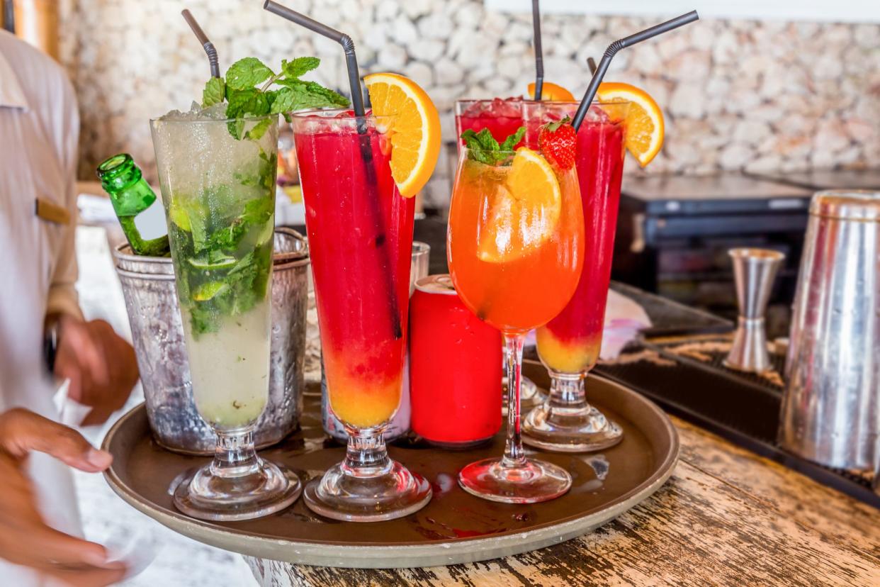 Male waiter serving variation cocktails