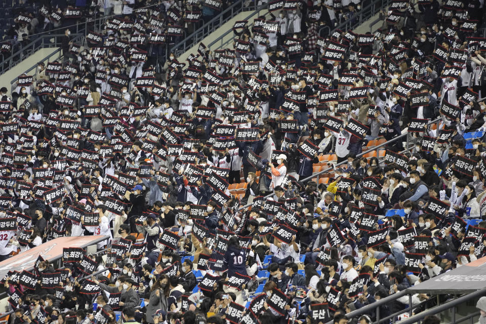 FILE- Baseball fans who are fully vaccinated or tested negative for the virus within the last 48 hours or under 18 years old, cheer their teams during the wildcard baseball game for the KBO postseason between Kiwoom Heroes and Doosan Bears in Seoul, South Korea, on Nov. 1, 2021. (AP Photo/Lee Jin-man, File)