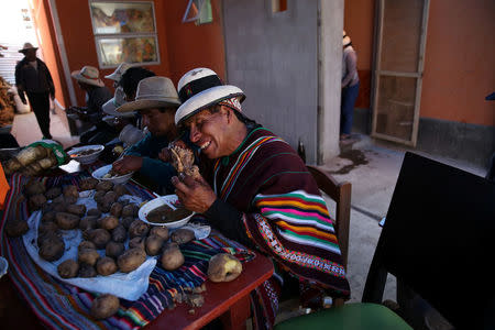 Reynaldo Llanqui (R) and his friends have lunch, days after his wedding to Monica Lima, at his house in the town of Nueva Fuerabamba in Apurimac, Peru, October 2, 2017. REUTERS/Mariana Bazo