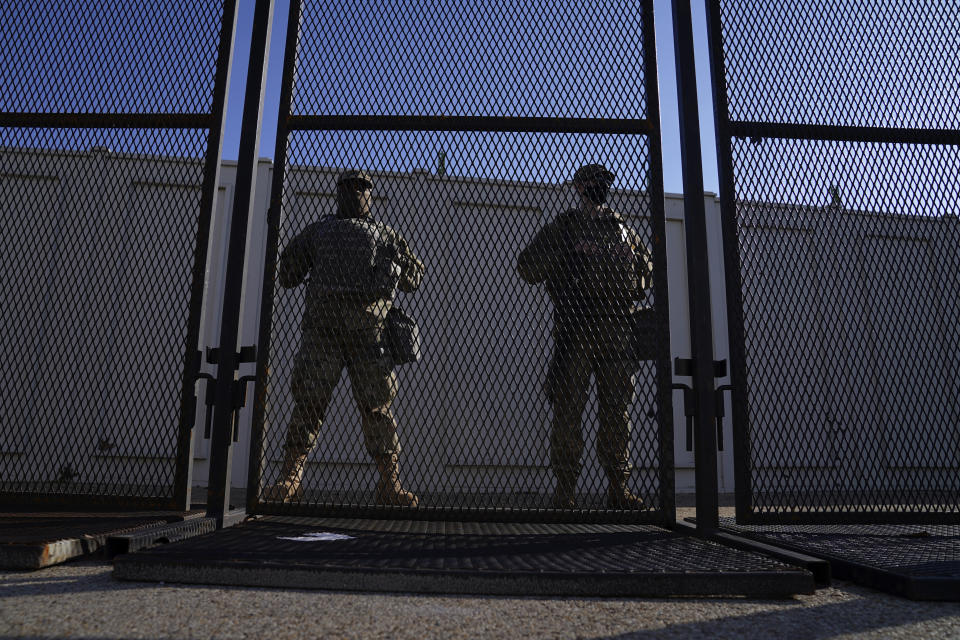 National Guard members stand behind a fence near the U.S. Capitol on Saturday, Jan. 16, 2021, in Washington as security is increased ahead of the inauguration of President-elect Joe Biden and Vice President-elect Kamala Harris. (AP Photo/John Minchillo)