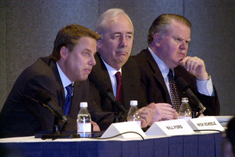 Ford Motor Company executives Bill Ford, Ford chairman & CEO, (L) Nick Scheele, president and chief operating officer (C) and Jim Padillo, group vice president, address the media regarding Ford's restructuring plans during a press conference in Dearborn, Mich., on January 11, 2002. A total of five Ford plants will close in the United States, eliminating 35,000 workers. UPI File Photo