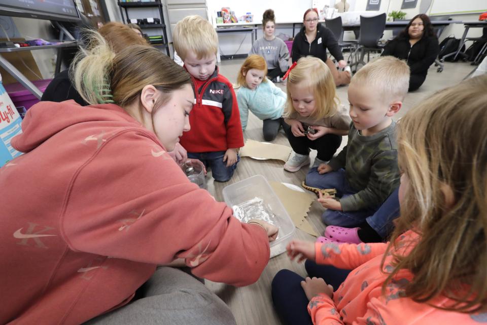Lylyan Puckett, left, shows children how to make snow as part of a quick science project during the Little Bluejays Preschool at Menasha High School.