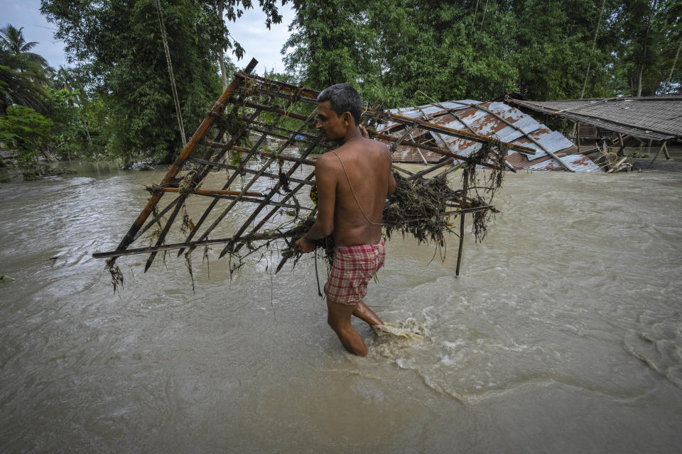 A villager salvages belongings from his flood-damaged house in Bali village, west of Guwahati, India, Friday, June 23, 2023. Tens of thousands of people have moved to relief camps with one person swept to death by flood waters caused by heavy monsoon rains battering swathes of villages in India’s remote northeast this week, a government relief agency said on Friday. (AP Photo/Anupam Nath)