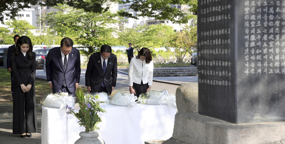 South Korean President Yoon Suk Yeol, center left, his wife Kim Keon Hee, left, Japan's Prime Minister Fumio Kishida and his wife Yuko Kishida bow to pay tribute at the Monument in Memory of the Korean Victims of the A-bomb near the Peace Park Memorial in Hiroshima, Japan, Sunday, May 21, 2023, on the sidelines of the G7 Summit Leaders' Meeting. (Lim Hun-jung/Yonhap via AP)