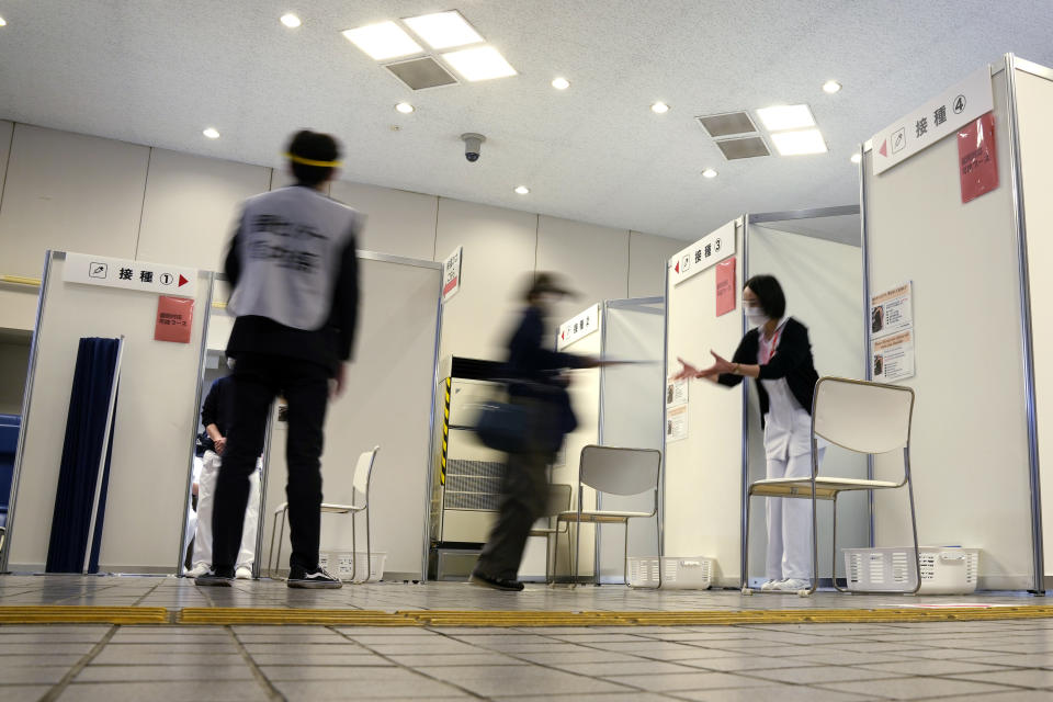 A local resident is guided to receive the booster shot of the Moderna coronavirus vaccine at a mass vaccination center operated by Japanese Self-Defense Force Monday, Jan. 31, 2022, in Tokyo. (AP Photo/Eugene Hoshiko, Pool)