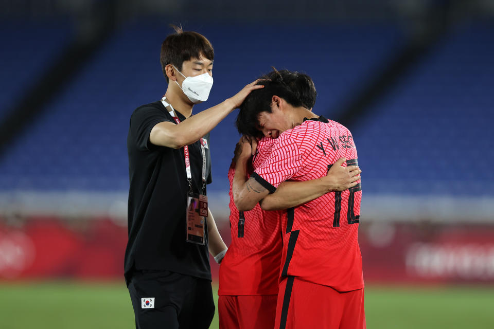 YOKOHAMA, JAPAN - JULY 31: Youngwoo Seol #12 of Team South Korea looks dejected as he is consoled by teammates following defeat in the Men's Quarter Final match between Republic Of Korea and Mexico on day eight of the Tokyo 2020 Olympic Games at International Stadium Yokohama on July 31, 2021 in Yokohama, Kanagawa, Japan. (Photo by Francois Nel/Getty Images)