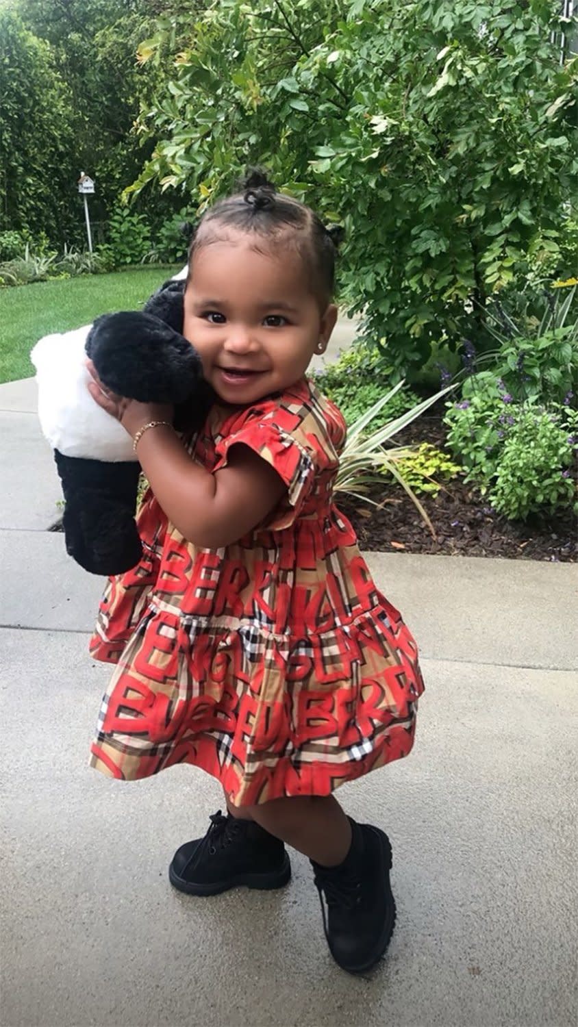 Khloé shared an adorable new photo of her 15-month-old daughter in a Burberry dress while holding a stuffed bear.