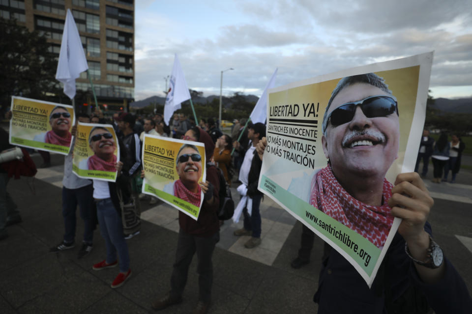 Supporters of the FARC political party holding posters of former leader Seuxis Hernandez, known by his war alias Jesus Santrich, rally outside the Attorney General's office in Bogota, Colombia, Wednesday May 15, 2019. Attorney General Nestor Martinez resigned after a special court charged with prosecuting war crimes during the country's civil conflict ruled that the former rebel leader should not be extradited to the United States on a drug warrant and should be freed from jail. (AP Photo/Fernando Vergara)