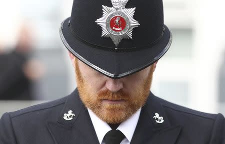 A police officer bows his head as the coffin of PC Keith Palmer, who was killed in the recent Westminster attack, is transported from the Palace of Westminster, where it laid overnight, to his funeral at Southwark Cathedral in central London, Britain April 10, 2017. REUTERS/Neil Hall