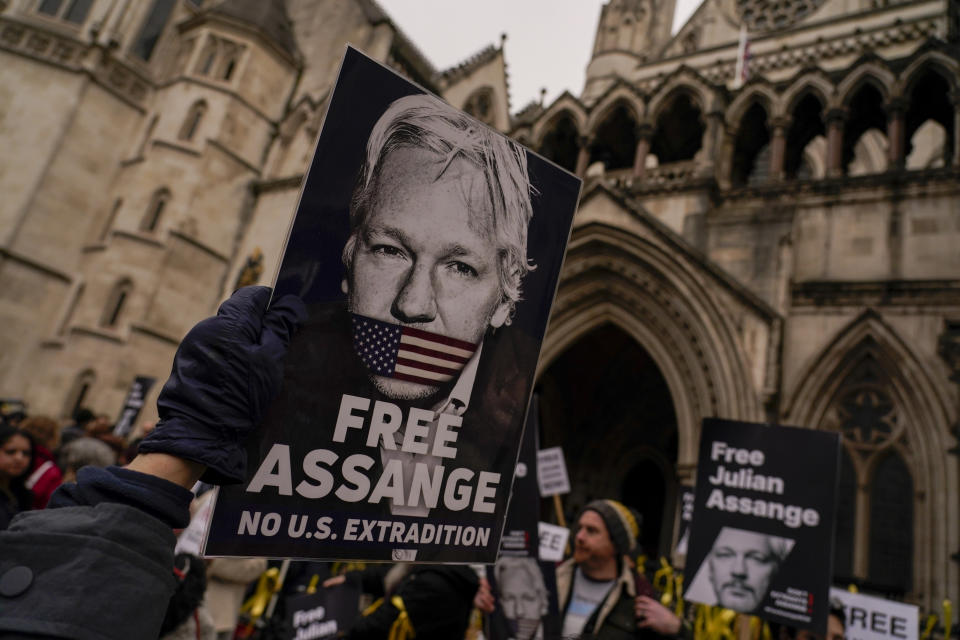 Demonstrators hold banners outside the Royal Courts of Justice in London, Tuesday, Feb. 20, 2024. WikiLeaks founder Julian Assange will make his final appeal against his impending extradition to the United States at the court. (AP Photo/Alberto Pezzali)