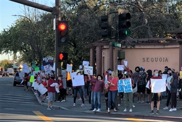 Parents demonstrate outside of the Sequoia Union High School District offices, in Redwood City, Tuesday, Feb. 23 as part of a campaign to pressure the district to reopen schools for on-campus learning.