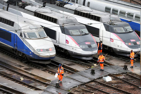 Workers pass by French TGV trains (high speed train) parked at a SNCF depot station in Charenton-le-Pont near Paris, France, May 31, 2016 as railway workers from the France's rail-operator SNCF will start a national railway strike on Tuesday evening. REUTERS/Charles Platiau