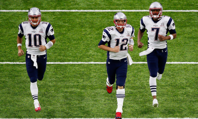New England Patriots quarterbacks Tom Brady, Jimmy Garoppolo, and Jacoby Brissett jog onto the field.