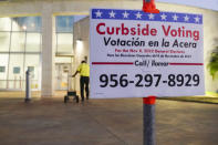 A sign advises voters how to vote curbside Friday, Oct. 28, 2022, outside an early voting polling location for the Texas midterm elections in Harlingen, Texas. (Denise Cathey/The Brownsville Herald via AP)