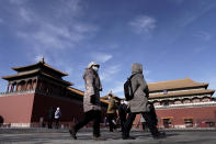 Visitors wearing face masks to help curb the spread of the coronavirus walk by Forbidden City in Beijing, Sunday, Jan. 10, 2021. More than 360 people have tested positive in a growing COVID-19 outbreak south of Beijing in neighboring Hebei province. (AP Photo/Andy Wong)