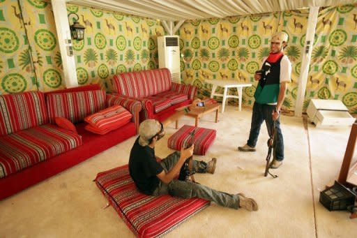 Libyan rebels take souvenir pictures inside the tent where Libyan leader Moamer Kadhafi used to receive foreign dignitaries at the Bab al-Aziziya compound in Tripoli