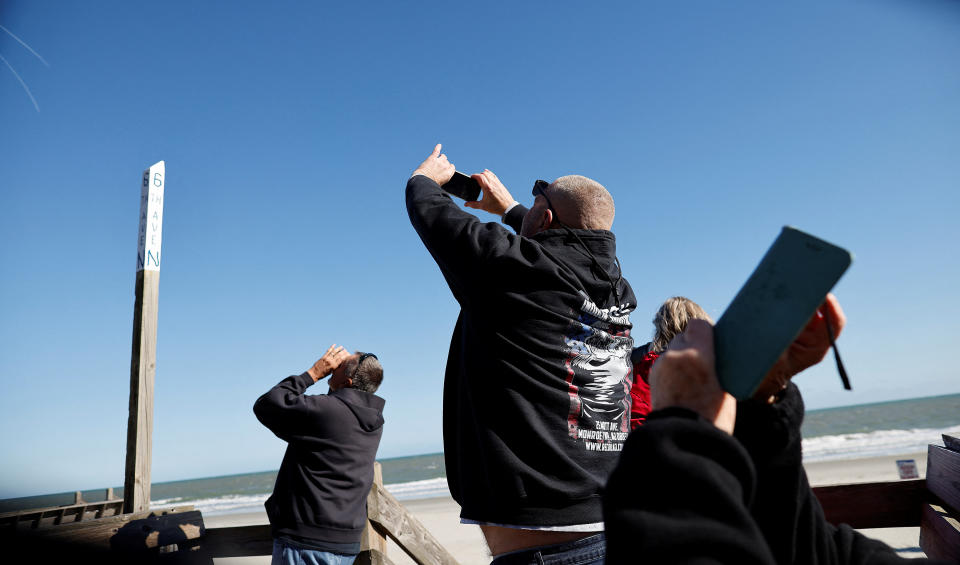 People photograph a suspected Chinese spy balloon as it floats off the coast in Surfside Beach, South Carolina, U.S. February 4, 2023.  REUTERS/Randall Hill