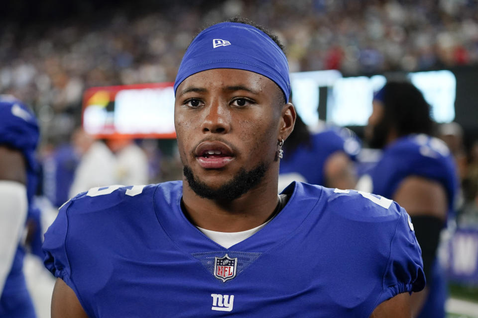 New York Giants' Saquon Barkley (26) watches during the second half of a preseason NFL football game against the Cincinnati Bengals Sunday, Aug. 21, 2022, in East Rutherford, N.J. (AP Photo/John Minchillo)
