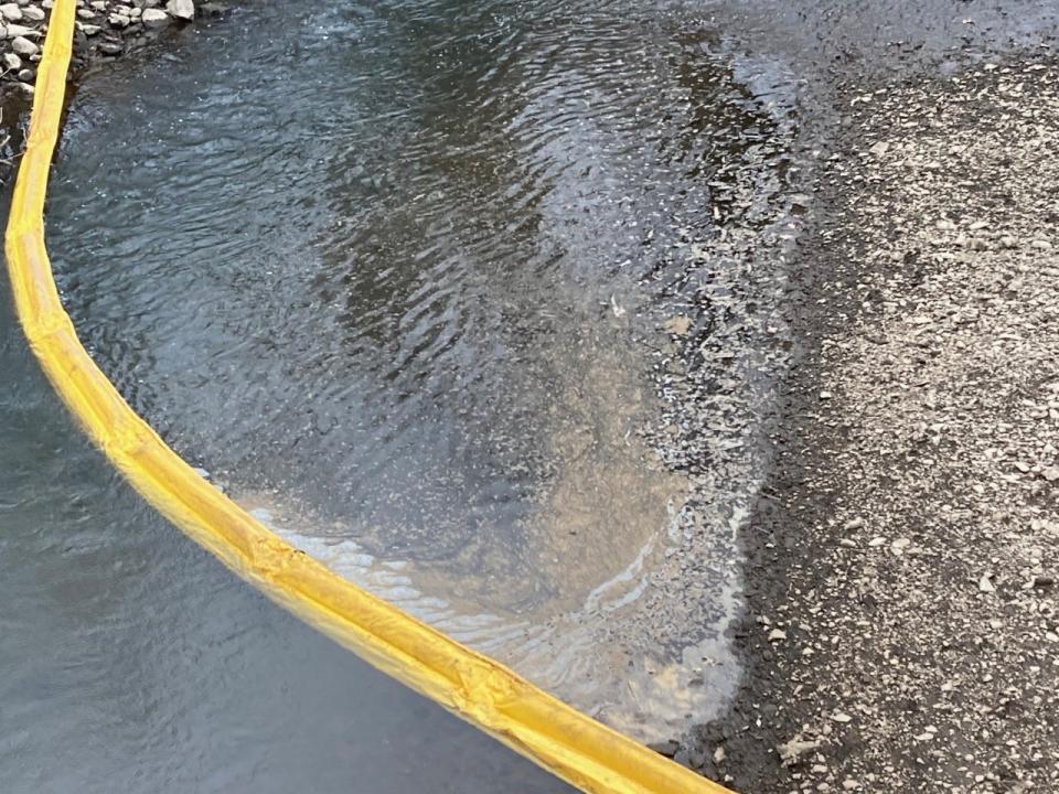 Environmental teams placed rubber barriers to slow the spread of contaminated water in the Otter Creek.