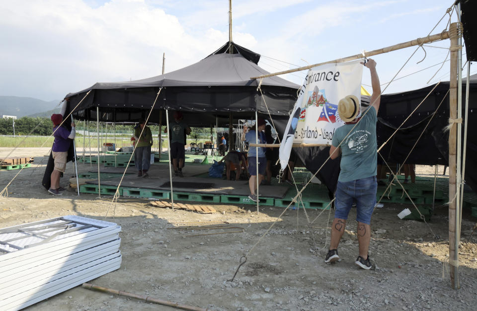 Attendees of the World Scout Jamboree prepare to leave a scout camping site in Buan, South Korea, Monday, Aug. 7, 2023. South Korea will evacuate tens of thousands of scouts by bus from a coastal jamboree site as Tropical Storm Khanun looms, officials said Monday. (Na Bo-bae/Yonhap via AP)