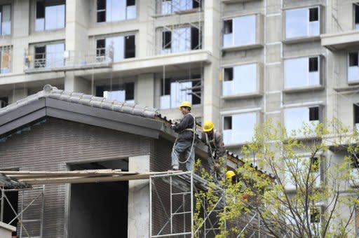 Workers stand on scaffoldings at a construction site in Beijing, April 12, 2012. China's growth slowed to 9.2 percent last year from 10.4 percent in 2010, dragged down by the global slowdown and domestic tightening aimed at controlling inflation