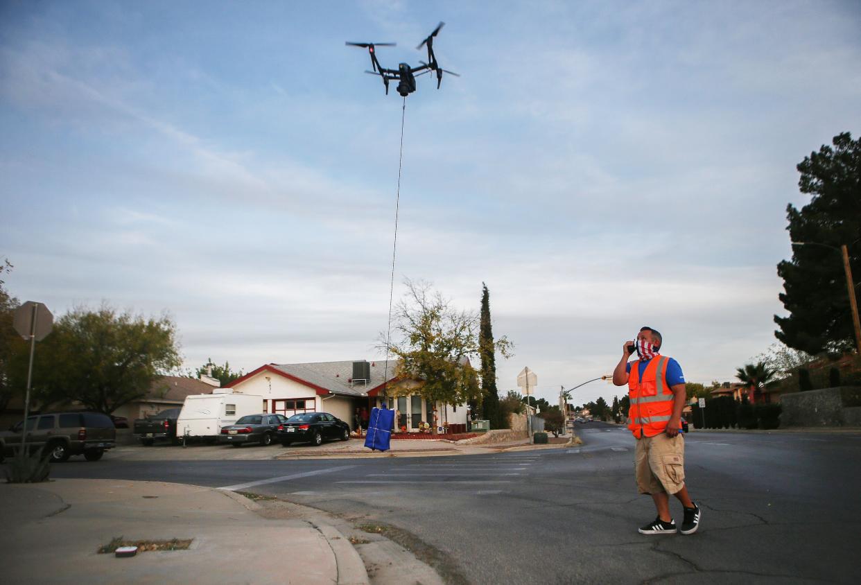 DroneUp pilot Chris Holmes visually observes for safety a drone arriving to deliver a COVID-19 self collection test kit to a home, after being ordered from Walmart by a resident, amid a Covid-19 surge in El Paso on Nov. 20, 2020 in El Paso, Texas. Residents who live within 1.5 miles of the Walmart Supercenter in East El Paso are eligible for the free kits as part of a drone delivery pilot program.