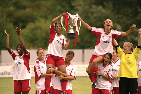 Parminder Nagra and Keira Knightley being hoisted up by their teammates as they hold a trophy.