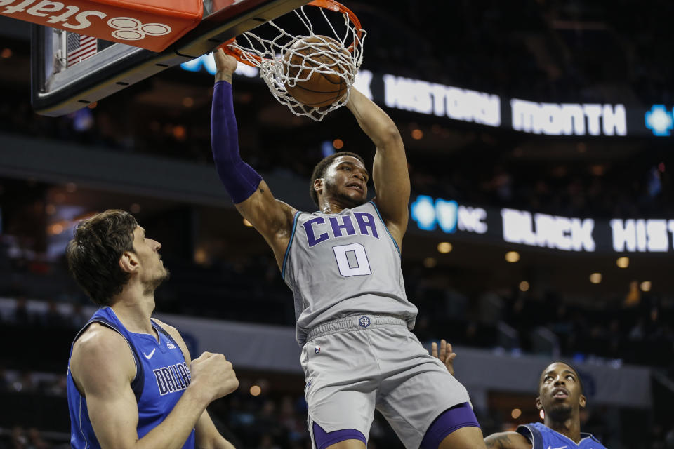 CORRECTS ID TO BOBAN MARJANOVIC NOT KRISTAPS PORZINGIS Charlotte Hornets forward Miles Bridges (0) dunks as Dallas Mavericks forward Boban Marjanovic, left, looks on in the first half of an NBA basketball game in Charlotte, N.C., Saturday, Feb. 8, 2020. (AP Photo/Nell Redmond)