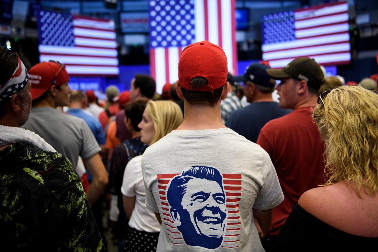 A man wears a t-shirt with a graphic of former US President Ronald Reagan at a rally.