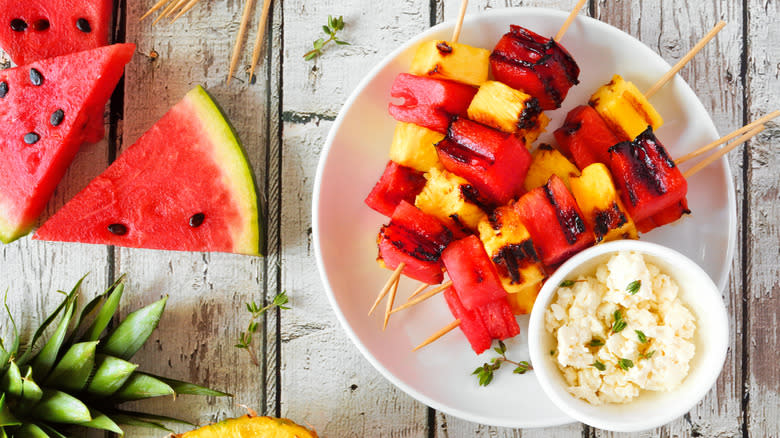 Grilled fruit kabobs on table