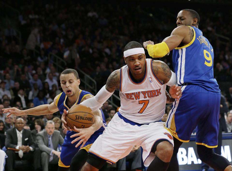 Golden State Warriors' Stephen Curry, left, knocks the ball away from New York Knicks' Carmelo Anthony (7) as Warriors' Andre Iguodala (9) defends during the first half of an NBA basketball game on Friday, Feb. 28, 2014, in New York. (AP Photo/Frank Franklin II)