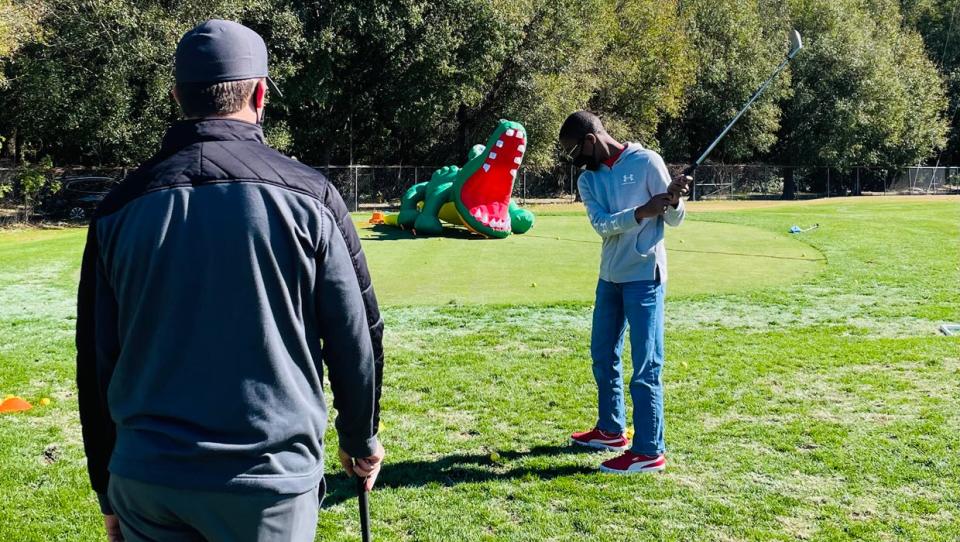 Facilities such as the Brentwood Golf Club on the Northside, with its First Tee affiliation, are helping bring minority youth such as Mario Reaves of Jacksonville into the game. He gets a chipping lesson from First Tee coach Ryan Sauer.