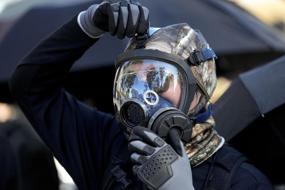 A protester marches during a demonstration in opposition to a new police training center, Monday, Nov. 13, 2023, in Atlanta. (AP Photo/Mike Stewart)